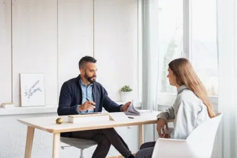 Jugendliche sitzt mit Psychologe am Tisch